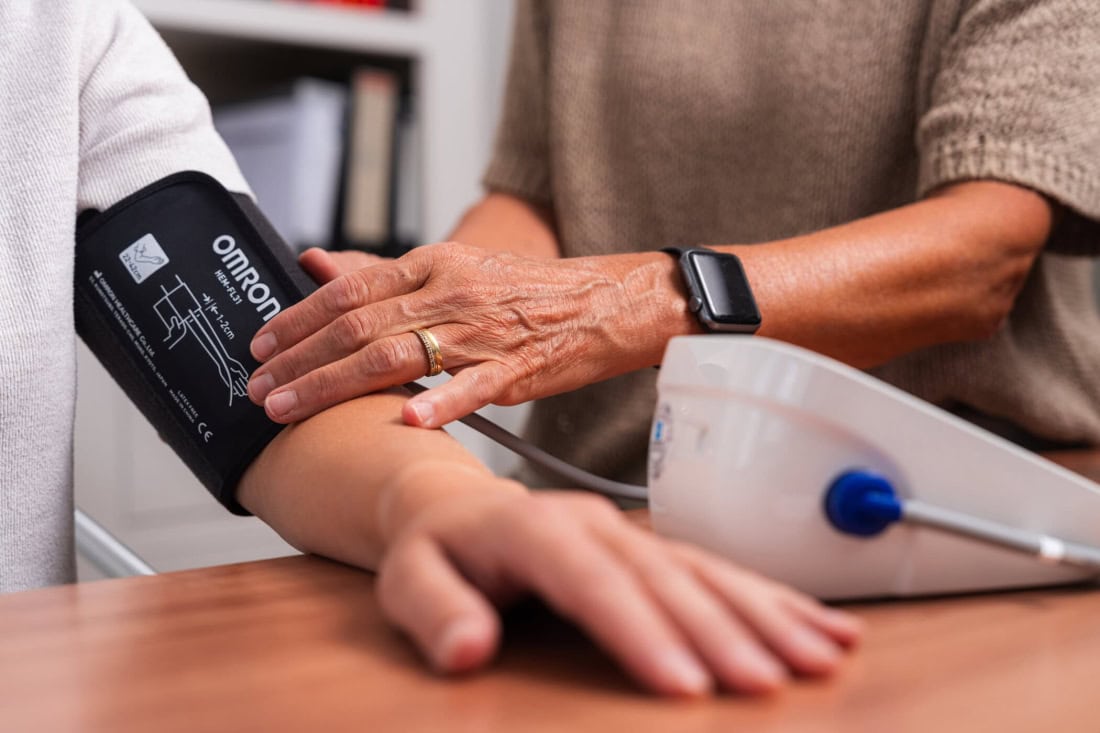 Home blood pressure measurement with digital blood pressure monitor and doctor or healthcare professional.