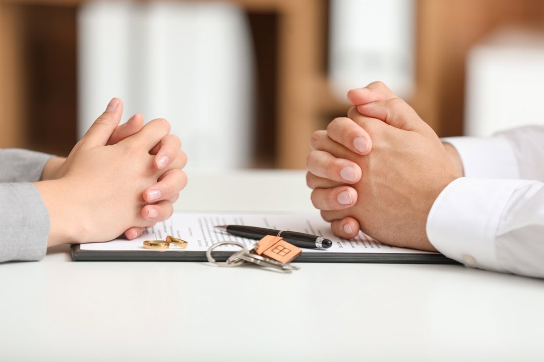 A negotiation of divorce information between two people with hand gestures.