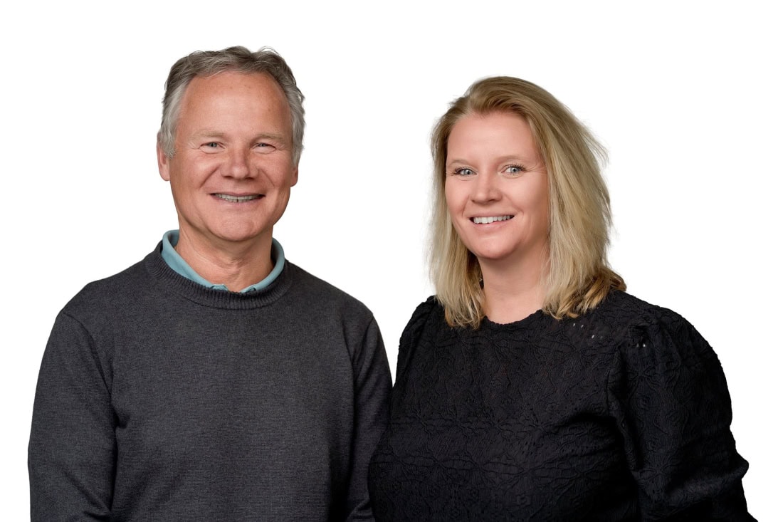 Zakenkoppel glimlachend in professionele setting, focus op vertrouwen en service.